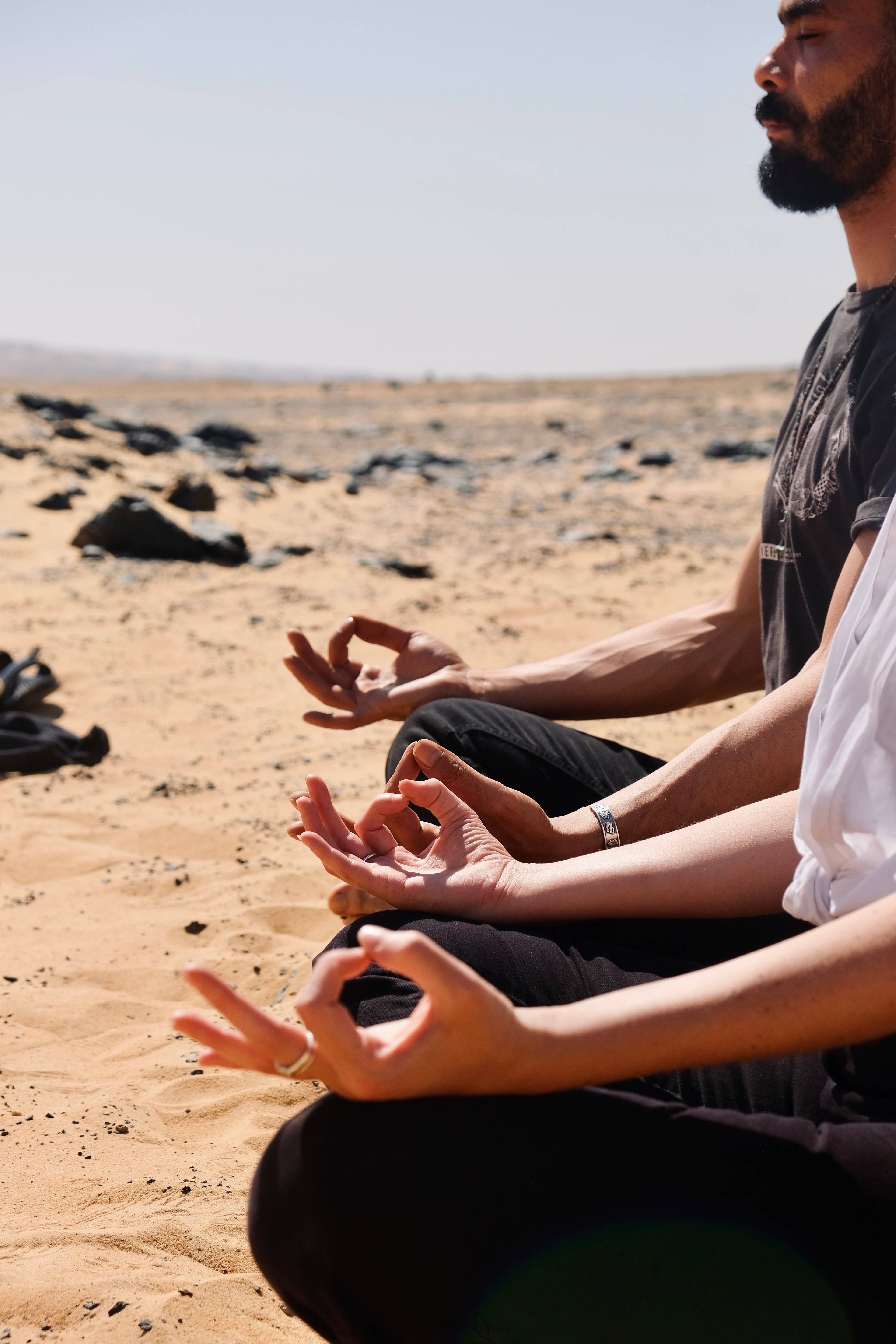 Couple in mudra pose meditation in the desert